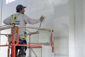 Elkhart, IN industrial painter spray painting a wall