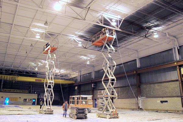 spray painting a metal deck ceiling in a warehouse